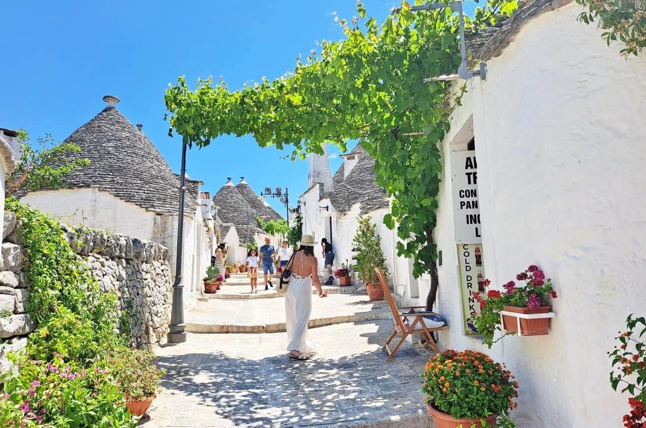  Alberobello, Rione Monti, whitewashed Trulli and flowers